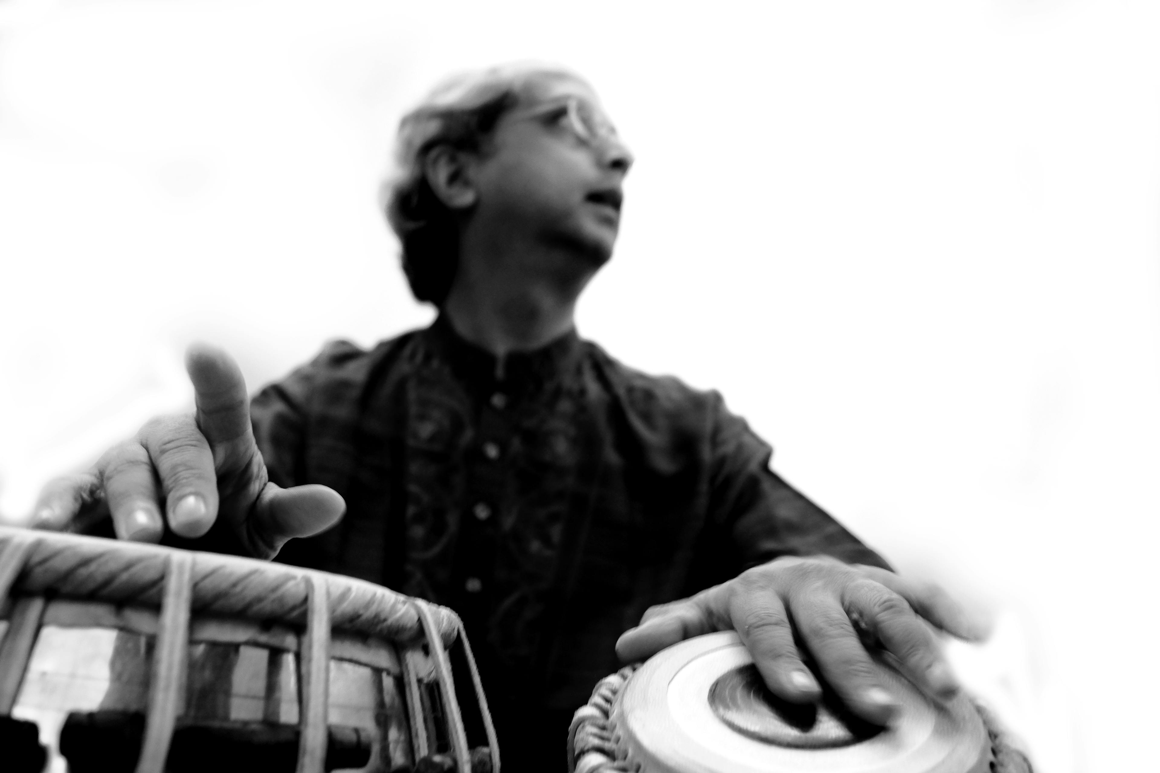 Black and white photo of Yogesh Samsi where the tabla is in focus
