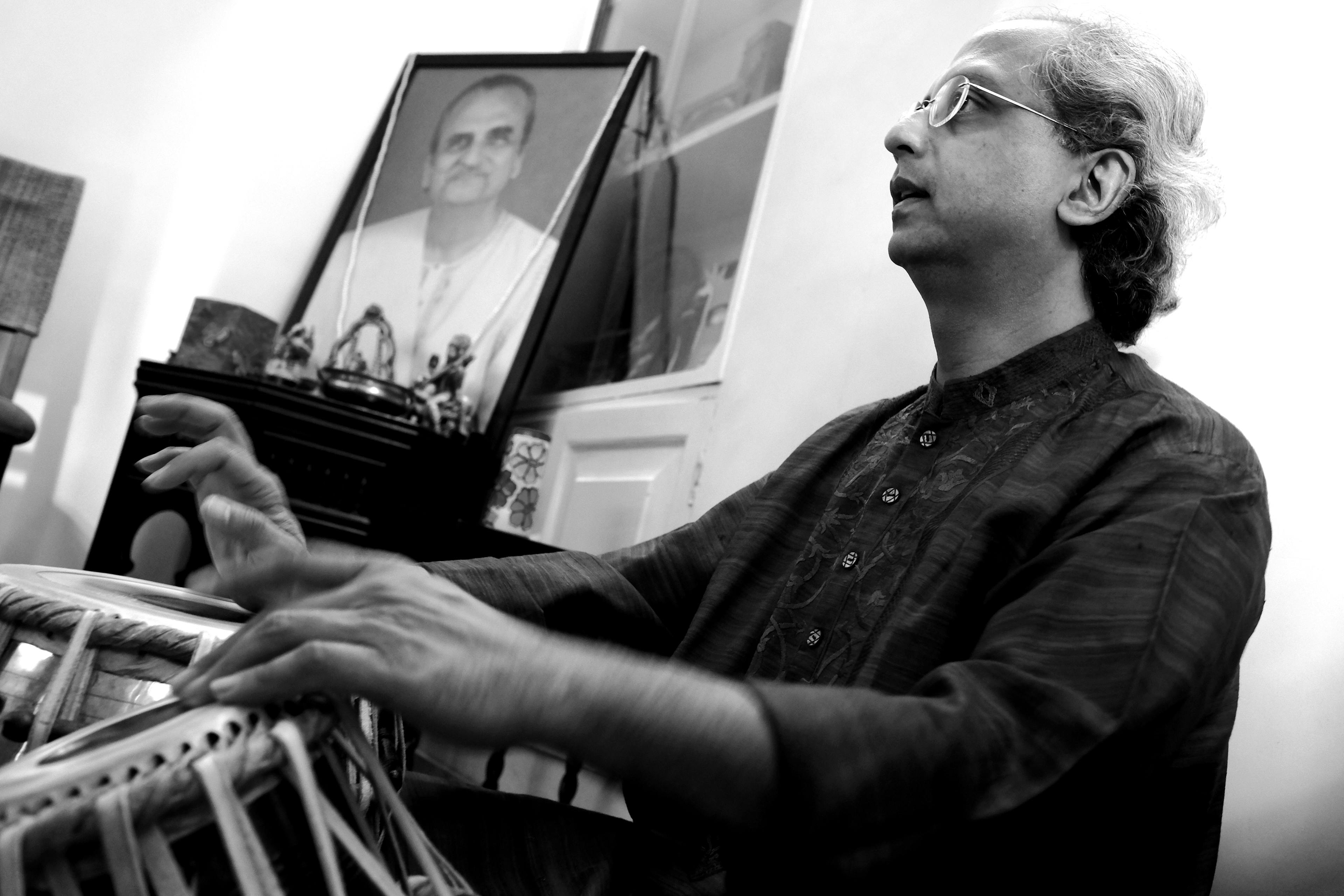 Yogesh Samsi playing tabla in front of a picture of his father Pt. Dinkar Kaikini